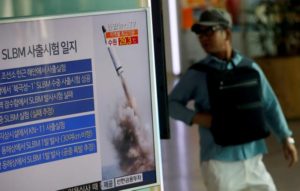 A passenger walks past a TV screen broadcasting a news report on North Korea's submarine-launched ballistic missile fired from North Korea's east coast port of Sinpo, at a railway station in Seoul, South Korea, August 24, 2016 REUTERS/Kim Hong-Ji/File Photo